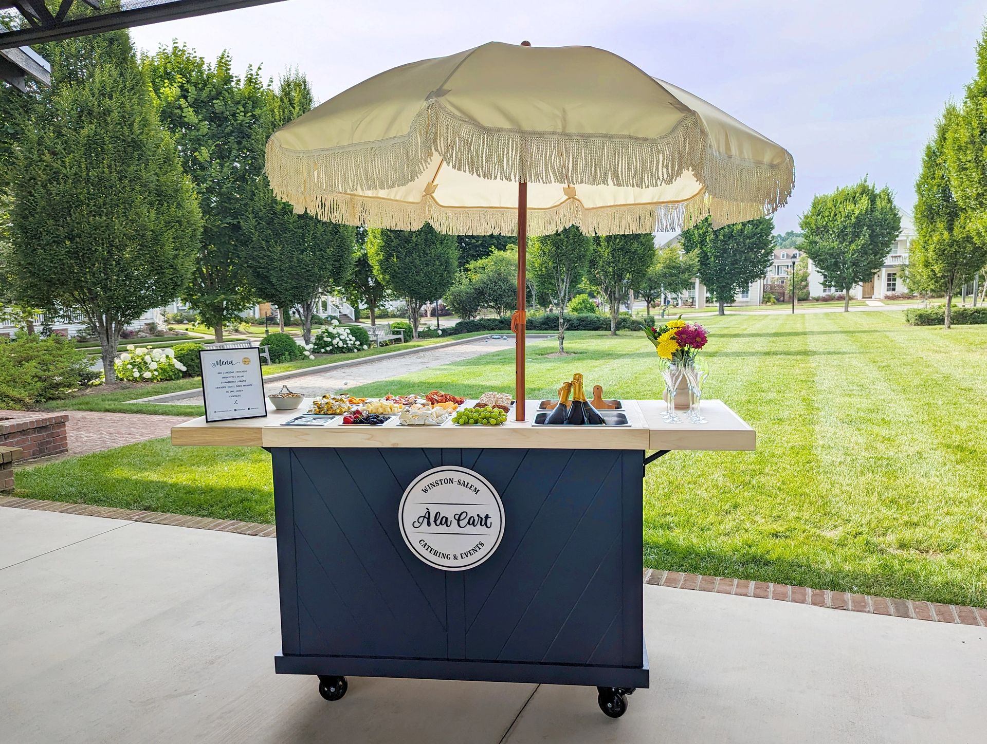 À La Cart charcuterie cart set up at a wedding reception in Winston-Salem, NC with curated cheeses, meats, and fruits